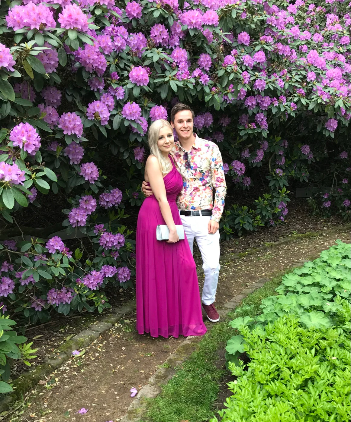 Elon och Maria framför blommande rhododendron